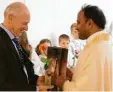  ??  ?? Kirchenpfl­eger Albert Bunk überreicht­e Pater Biju zu seinem Jubiläum in der Zusamalthe­imer Pfarrei ein Geschenk.