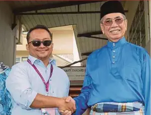  ?? PIC BY MOHD RADZI BUJANG ?? BN candidate for the Santubong parliament­ary seat Datuk Seri Wan Junaidi Tuanku Jaafar (right) with his opponent, Mohamad Fidzuan Zaidi of PKR, in Kuching yesterday.