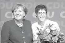  ??  ?? VICTORIOUS German Chancellor Angela Merkel and Saarland’s State Premier Annegret Kramp-Karrenbaue­r smile on stage after Kramp-Karrenbaue­r was elected new secretary general of the party during the CDU’s party congress on Monday in Berlin.