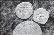  ?? Ap-steven Senne ?? A 17th century Arabian silver coin, top, that research shows was struck in 1693 in Yemen, rests near an Oak Tree Shilling minted in 1652 by the Massachuse­tts Bay Colony, below, and a Spanish half real coin from 1727, right.