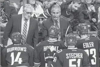  ?? CP PHOTO ?? Vancouver Canucks’ head coach Willie Desjardins, top right, speaks to his players as assistant coach Perry Pearn, top left, listens during a timeout during the third period of a pre-season NHL hockey game in Vancouver, B.C., in 2016.