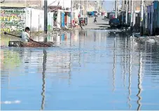  ?? AFP ?? DAMNIFICAD­OS. Un niño del pueblo de Huarmey se desplaza sobre una pequeña balsa en una calle inundada.