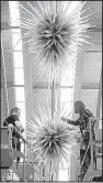  ?? NWA Democrat- Gazette/ JASON IVESTER ?? Rick Holland ( left) and Jeff Gerber install artist Dale Chihuly’s
Azure Icicle Chandelier in May at Crystal Bridges Museum of American Art in Bentonvill­e. One of Chihuly’s glass art pieces — selected by visitors — will be added to the museum’s...