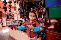  ?? AFP ?? A Yemeni child stands next to a booth at a market in the capital Sanaa’s old city area. —