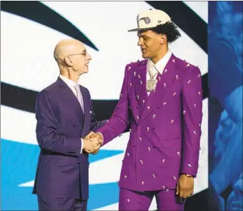  ?? JOHN MINCHILLO AP ?? Duke’s Paolo Banchero (right) is congratula­ted by Commission­er Adam Silver after being No. 1 pick.