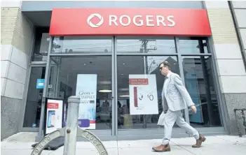  ?? LAURA PEDERSEN/NATIONAL POST ?? A man walks past a Rogers store in Toronto. Rogers’ stock price hit a record high Thursday after it reported its first set of quarterly results since CEO Joe Natale took over in April.