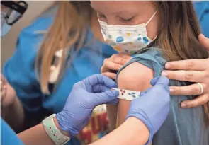  ?? JOSHUA A. BICKEL/COLUMBUS DISPATCH ?? Marin Ackerman, 10, of Upper Arlington, gets a bandage after receiving a dose of the Pfizer-biontech COVID-19 vaccine during a clinic for kids ages 5- to 11-year-olds on Nov. 3 at Nationwide Children’s Hospital. The FDA recently authorized use of the Pfizer-biontech COVID-19 vaccine for use in younger children.