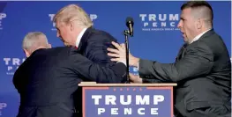  ?? — AP ?? Secret Service agents rush Republican presidenti­al candidate Donald Trump off the stage at a campaign rally in Reno, Nevada.