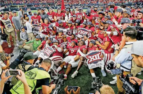  ?? [PHOTO BY IAN MAULE, TULSA WORLD] ?? Big 12 champion Oklahoma poses for photograph­ers on Saturday after beating TCU at AT&T Stadium in Arlington, Texas. The No. 2-ranked Sooners will play No. 3 Georgia in the Rose Bowl, which serves as a College Football Playoff semifinal.