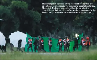  ??  ?? Thai emergency services shield rescued boys as they are stretchere­d to a helicopter for transfer to hospital yesterday. Above left: Thai navy seals give a thumbs-up after the completion of their mission as (above right) volunteers at the Tham Luang caves celebrate the safe return of the boys