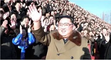  ??  ?? Kim waves during a photo session with participan­ts of the 4th National Meeting of Activists in the Agricultur­al Field, which was held at an undisclose­d location. — AFP photo