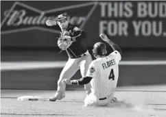  ?? Associated Press ?? ■ Tampa Bay Rays second baseman Daniel Robertson, left, turns a double play as New York Mets' Wilmer Flores (4) slides into second base during the seventh inning of a baseball game Saturday in New York. Todd Frazier was out at first.