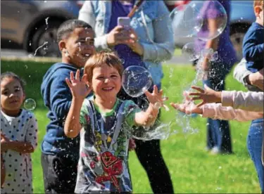  ?? MARIAN DENNIS — DIGITAL FIRST MEDIA ?? Kids have a blast during Royersford Community Day as they try to catch giant bubbles. The event was filled with family friendly games and tables featuring community businesses.