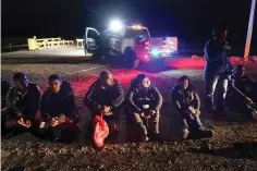  ?? The Associated Press ?? ■ Migrants wait to be processed after crossing the border on Jan. 6 near Yuma, Ariz. The Biden administra­tion says it will generally deny asylum to migrants who show up at the U.S. southern border without first seeking protection in a country they passed through. That mirrors an attempt by the Trump administra­tion that never took effect because it was blocked in court.