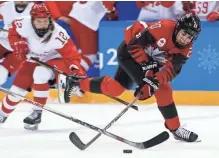  ?? ASSOCIATED PRESS ?? Sarah Nurse (right) of Canada reaches for the puck during the first period of Sunday’s preliminar­y round game against the team from Russia.