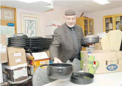  ?? MARIE-FRANCE COALLIER ?? Mehmet Deger, president of Dorval Mosque, inspects donations. The mosque has a room full of furniture, clothes and a variety of household items.