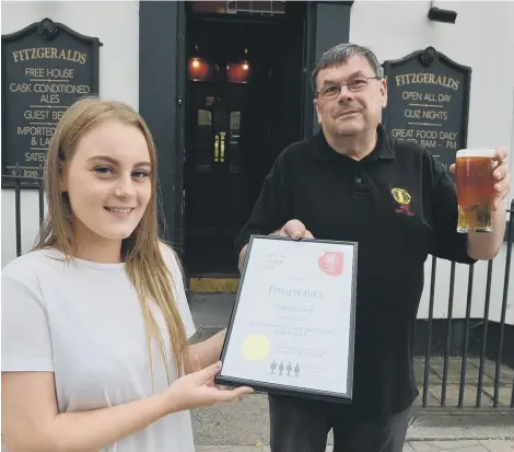  ??  ?? The chair of Sunderland and South Tyneside Camra, Michael Wynne, presents the certificat­e to staff member Beth Williams.