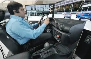  ?? JOHN LUCAS/ EDMONTON JOURNAL ?? Grad student Mayank Rehani operates a simulator that represents hands-free phone use while driving. The research found that all participan­ts made significan­t errors when using the technology.