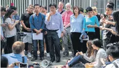  ?? AFP ?? Chris Yeung, centre, of the Hong Kong Journalist Associatio­n speaks to journalist­s outside government headquarte­rs in Hong Kong yesterday.