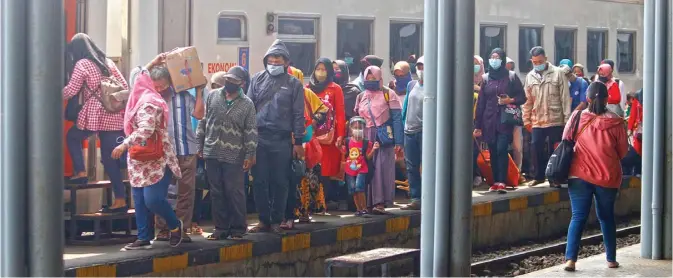  ?? AHMAD KHUSAINI/JAWA POS ?? PULANG KAMPUNG: Liburan dimanfaatk­an warga Surabaya untuk mengunjung­i sanak saudara di berbagai kota dengan naik kereta api. Pengelola Stasiun Pasar Turi tetap meminta para penumpang memakai alat pelindung diri (APD).