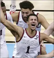  ?? ANDY LYONS — THE ASSOCIATED PRESS ?? Gonzaga’s Jalen Suggs celebrates with teammates after making a game-winning 3-point basket in overtime to defeat UCLA in Saturday’s NCAA Tournament semifinals.