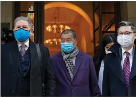  ?? (AP/Kin Cheung) ?? Hong Kong pro-democracy activist and media tycoon Jimmy Lai (center) leaves court Thursday during a break in his hearing.