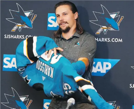  ?? JOSIE LEPE/THE ASSOCIATED PRESS ?? Newly acquired San Jose Sharks defenceman Erik Karlsson puts on a Sharks jersey for the first time Wednesday.