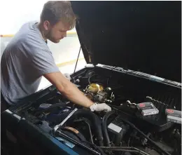  ??  ?? My son David busy changing the Jeep’s eight spark plugs.