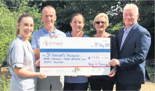  ??  ?? Latest donation John and Isabel Gilchrist (far right) have raised thousands for St Vincent’s Hospice