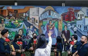  ?? Jon Shapley / Staff photograph­er ?? Gracie Saenz, a former City Council member, talks about the mural “MexicanAme­rican History & Culture in 20th Century Houston” to a group of students from the Sam Houston Math, Science and Technology Center High School Mariachi Band on Friday. Houston has a number of tours planned to mark Hispanic Heritage Month.