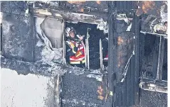  ??  ?? A fire officer in the blackened shell of Grenfell Tower after fire engulfed the building