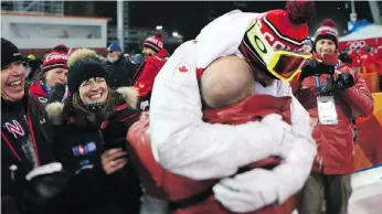  ??  ?? Mikael Kingsbury celebrates his gold medal in the men’s moguls final Monday with solid hug from his coach while his father and mother, left, look on. “I’m the Olympic champion for the rest of my life,” Kingsbury said.