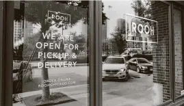  ?? Olivia Obineme / Bloomberg ?? A sign notifies customers that the restaurant offers only pickup and delivery outside ROOH Chicago. With each week, more data emerges to show the pandemic is permanentl­y reshaping the restaurant industry.
