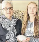  ?? ETHAN PAQUET/SALTWIRE NETWORK ?? Mae and Alecia Arsenault admire the snowball Mae kept in her freezer for 11 years, a gift from her granddaugh­ter.