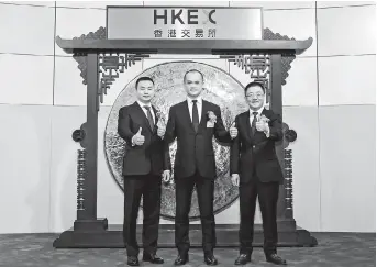  ??  ?? Meituan Dianping chairman and CEO Wang Xing (center) poses with two other cofounders and senior vice presidents, Mu Rongjun (left) and Wang Huiwen (right) at the Hong Kong stock exchange yesterday. — Ti Gong