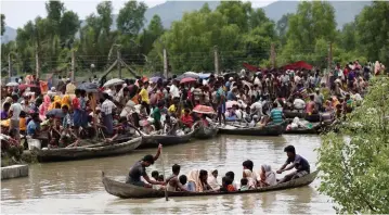  ?? (Reuters) ?? A BOAT carrying Rohingya refugees is seen leaving Myanmar through the Naf river.