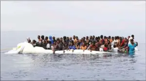  ?? ABDULLAH ELGAMOUDI/AFP ?? Migrants wait to be rescued from a sinking dingey off the Libyan coast on March 20 as they attempted to cross the Mediterran­ean to Europe.