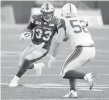  ?? TREVOR HAGAN, THE CANADIAN PRESS ?? Bombers running back Andrew Harris heads up field in front of Als linebacker Nicolas Boulay on Thursday.