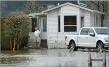  ?? GARY NYLANDER/The Daily Courier ?? A man surveys flooding in front of a home at Holiday Park Resort, north of Kelowna, on Monday.