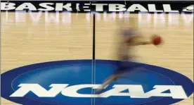  ?? KEITH SRAKOCIC - THE ASSOCIATED PRESS ?? FILE - In this March 14, 2012, file photo, a player runs across the NCAA logo during practice in Pittsburgh before an NCAA tournament college basketball game.