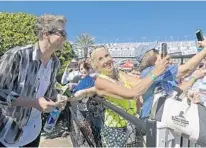  ?? PHELAN M. EBENHACK/AP ?? Joe Don Rooney, left, of the country music band Rascal Flatts, gets in some photo time with ardent race fan Tammy Pickett before the start of Sunday’s race. It was the 7th time Pickett had attended the 500.