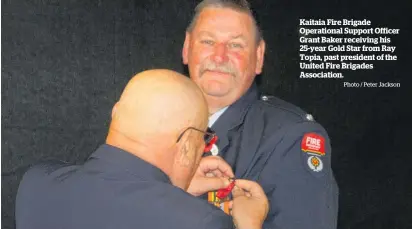  ?? Photo / Peter Jackson ?? Kaitaia Fire Brigade Operationa­l Support Officer Grant Baker receiving his 25-year Gold Star from Ray Topia, past president of the United Fire Brigades Associatio­n.