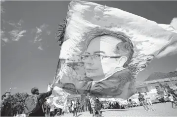  ?? FERNANDO VERGARA/AP ?? A supporter of Colombian presidenti­al candidate Gustavo Petro holds a flag emblazoned with Petro’s image before a closing campaign rally Monday in Zipaquira, Colombia. Voters are scheduled to go to the polls on Sunday.