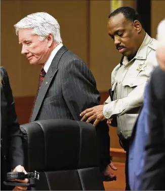  ?? BOB ANDRES/BANDRES@AJC.COM ?? Claud “Tex” McIver, 75, is handcuffed by a Fulton County sheriff’s deputy and led from the courtroom after the verdict. Jurors didn’t buy his claim that his wife’s killing was an accident.