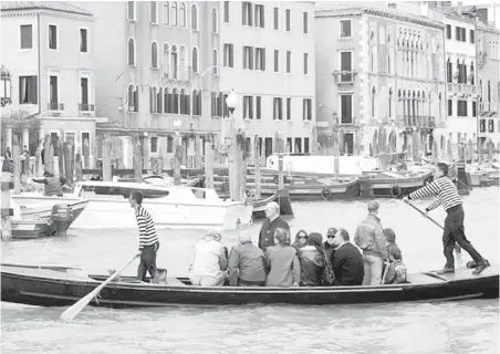  ??  ?? In Venice, only three “traghetti” (shuttle gondolas) still ferry voyagers across the Grand Canal from establishe­d stops.