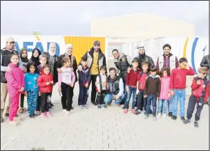  ??  ?? Members of the Najat Charitable Society and the Human Rights Center of the Kuwaiti Lawyers Associatio­n with Syrian orphans in the Turkish Sanliurfa.