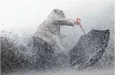  ?? FOTO: BOB EDME/DPA ?? Da hilft auch kein Regenschir­m mehr: Heftige Wellen schlagen gegen den Hafendamm von Biarritz vor der Atlantikkü­ste.