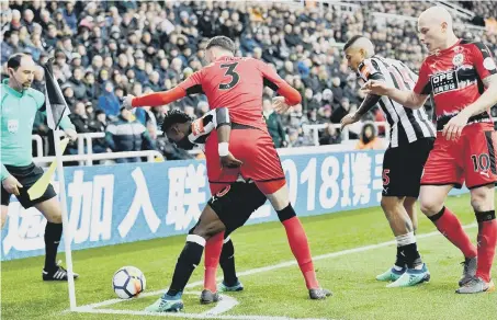  ??  ?? Newcastle winger Christian Atsu defends the ball under pressure in the corner flag against Huddersfie­ld. Pictures by Frank Reid.