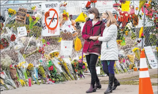  ?? David Zalubowski The Associated Press file ?? Mourners in March 2021 walk along the fence around the parking lot of a grocery store where a mass shooting occurred in Boulder, Colo. County commission­ers gave initial approval Tuesday to gun control ordinances.