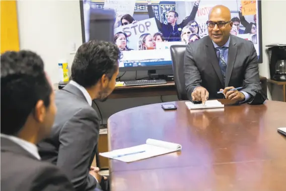  ?? Jessica Christian / The Chronicle ?? San Francisco Public Defender Manohar Raju attends a morning meeting with colleagues in his office. Raju supports state legislatio­n to create a pilot program called Be the Jury to improve the racial and economic diversity on juries. The concept of paying jurors more would allow more lowincome people to serve.